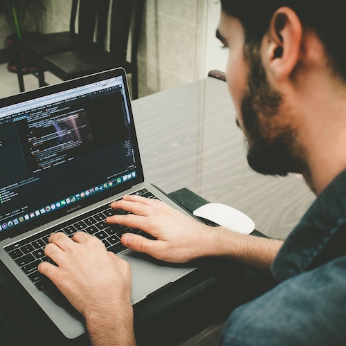 A picture a man typing on a laptop